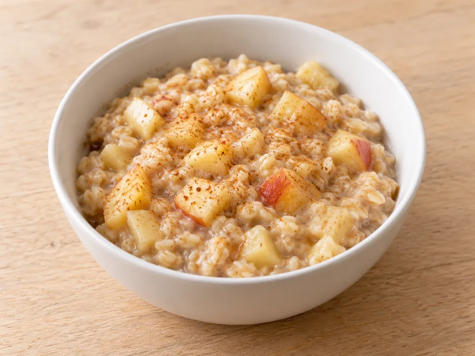 Warmer Haferbrei mit kleinen Apfelstücken und Zimt in einer Schale.