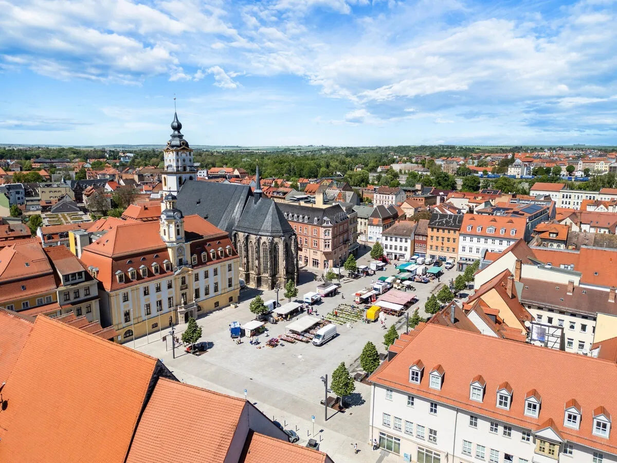 Blick auf den Marktplatz in Weißenfels mit Wochenmarkt, Rathaus und Marienkirche.